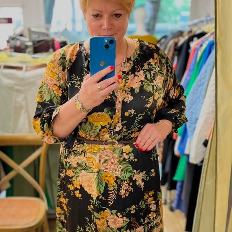 Juoda midi suknelė su geltonų ir persikinių gėlių raštu bei plona odine juostele per liemenį